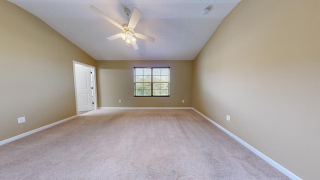 carpeted empty room featuring ceiling fan and lofted ceiling