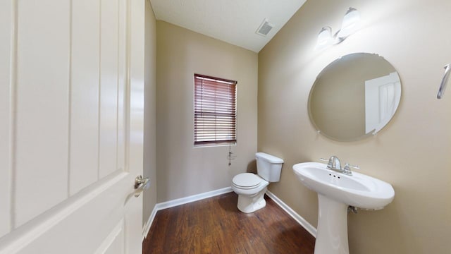 bathroom with hardwood / wood-style floors and toilet