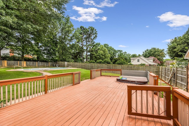 deck featuring a swimming pool with hot tub and a yard