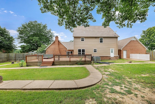 back of property with central AC unit, a deck, and a lawn