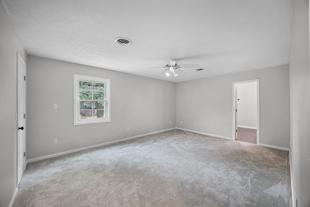 empty room with carpet flooring, ceiling fan, and a textured ceiling