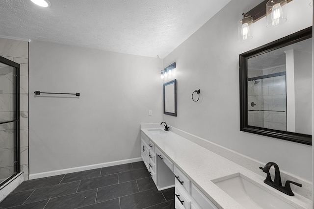 bathroom featuring tile patterned flooring, vanity, a textured ceiling, and walk in shower