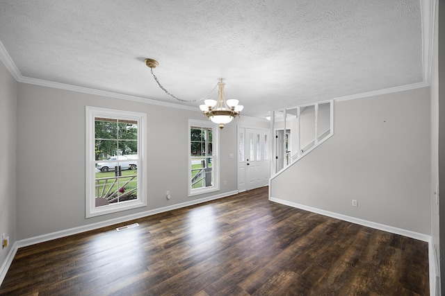 spare room with ornamental molding, dark wood-type flooring, a textured ceiling, and a notable chandelier