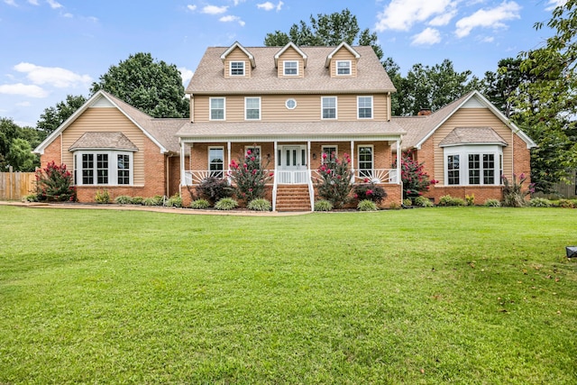 colonial inspired home with covered porch and a front yard