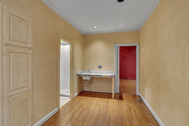 hall featuring light wood-type flooring and crown molding