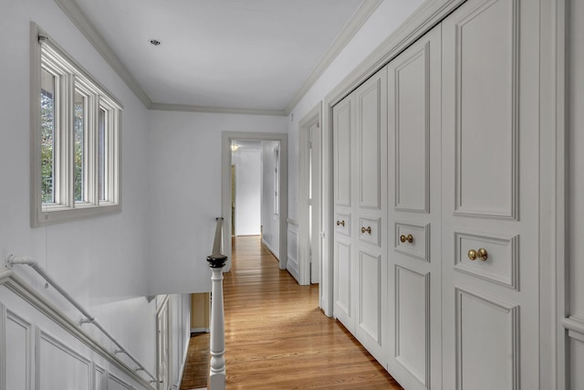 hallway featuring ornamental molding and light hardwood / wood-style flooring