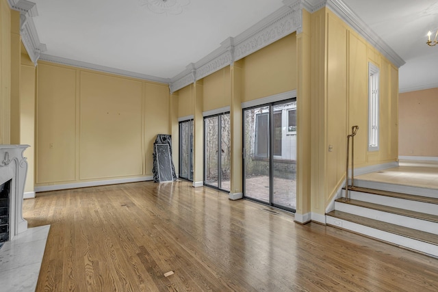 unfurnished living room featuring hardwood / wood-style flooring and crown molding