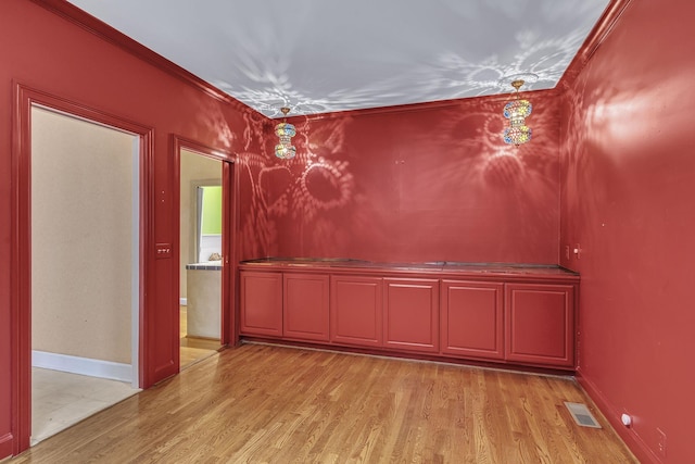 spare room featuring light hardwood / wood-style flooring and ornamental molding