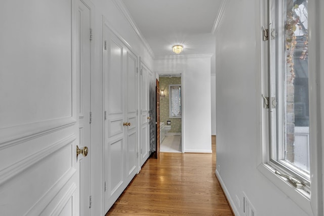 hallway with crown molding and light wood-type flooring