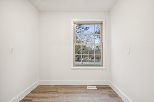 unfurnished room with hardwood / wood-style flooring and plenty of natural light