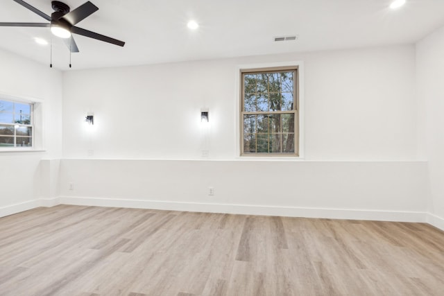 unfurnished room featuring a wealth of natural light, ceiling fan, and light hardwood / wood-style flooring