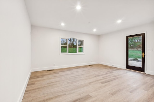 unfurnished room featuring a wealth of natural light and light hardwood / wood-style flooring