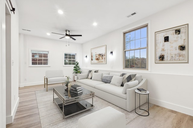 living room featuring ceiling fan and light wood-type flooring