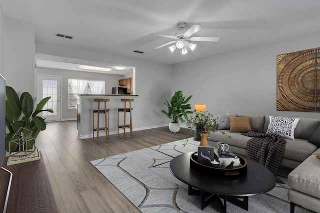 living room with wood-type flooring and ceiling fan