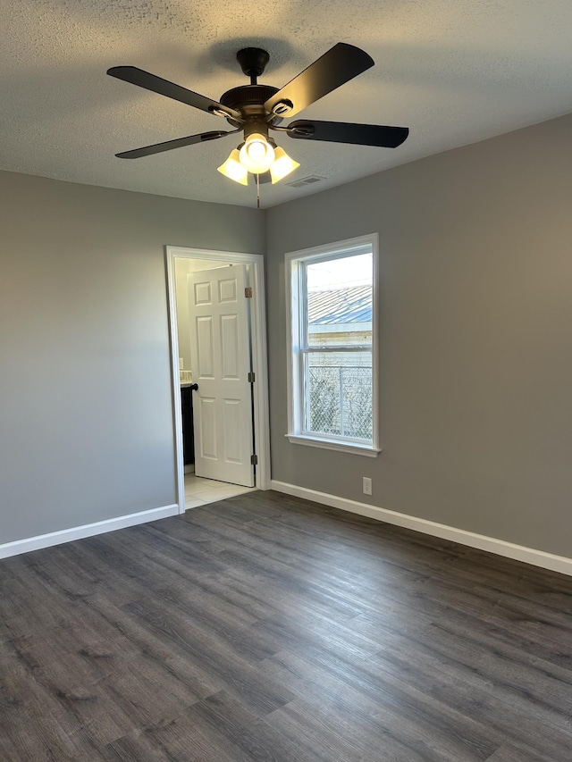 unfurnished room featuring a textured ceiling, dark hardwood / wood-style flooring, and ceiling fan