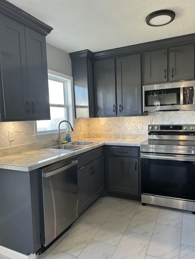121 Poplar St N, Cowan, TN 37318 - kitchen with appliances with stainless steel finishes, light marble finish flooring, a textured ceiling, light countertops, and tasteful backsplash
