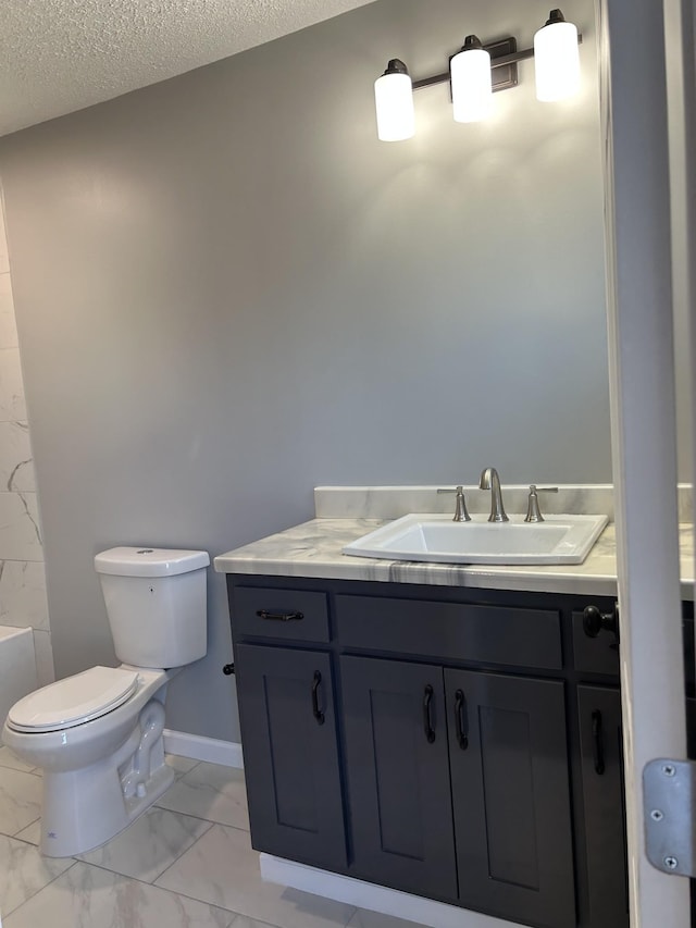 bathroom featuring vanity, toilet, and a textured ceiling