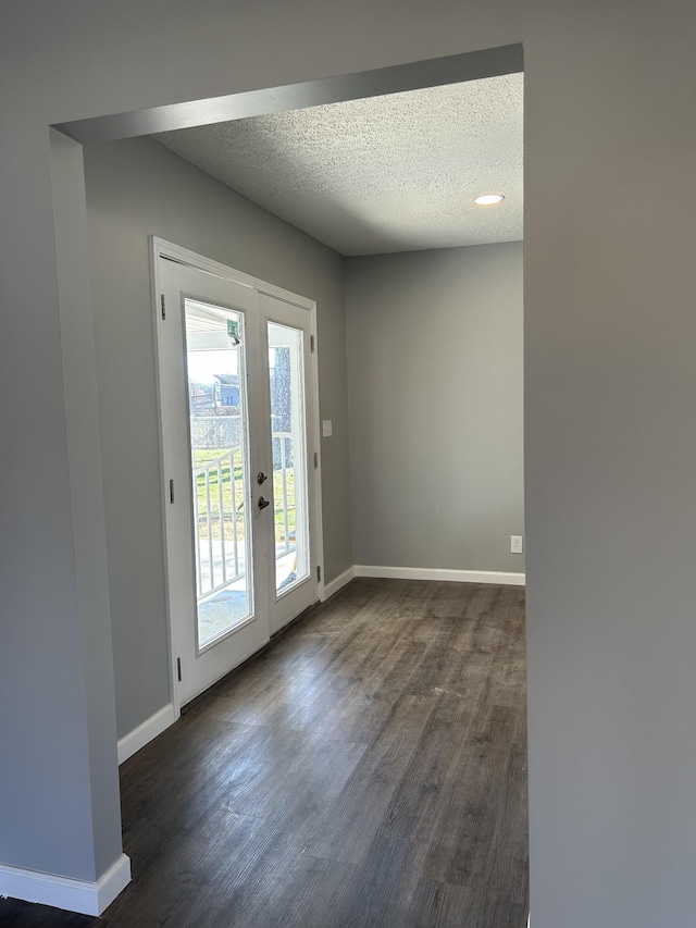 doorway to outside featuring french doors, dark hardwood / wood-style flooring, and a textured ceiling