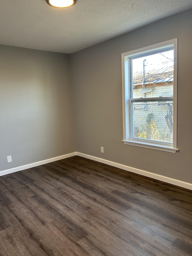 spare room with dark hardwood / wood-style flooring and a textured ceiling