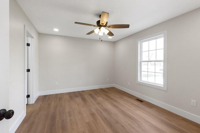 spare room featuring ceiling fan, plenty of natural light, and light wood-type flooring