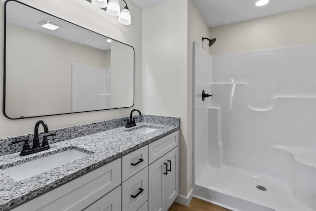 bathroom featuring vanity, hardwood / wood-style floors, and walk in shower