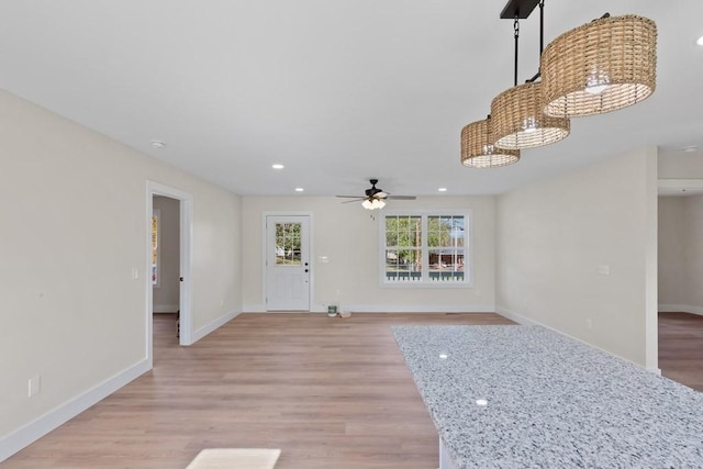 unfurnished living room with ceiling fan and light hardwood / wood-style flooring