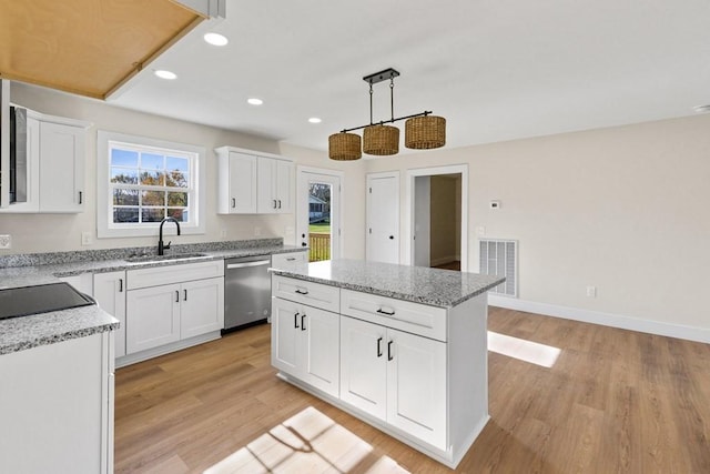 kitchen featuring pendant lighting, sink, dishwasher, a center island, and white cabinets