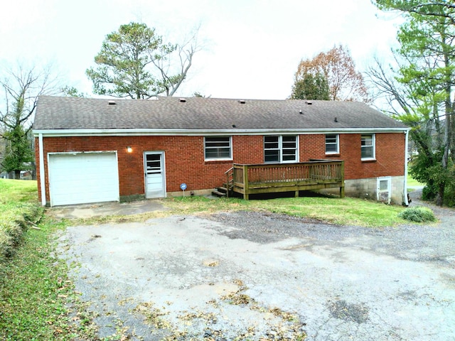 rear view of property featuring a garage and a deck