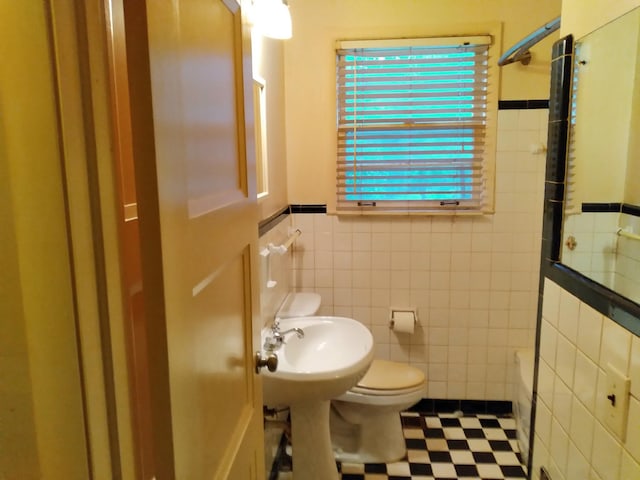 full bathroom with sink, bathtub / shower combination, tile walls, and toilet