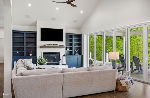 living room featuring dark hardwood / wood-style flooring, ceiling fan, plenty of natural light, and high vaulted ceiling