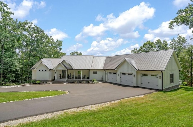 single story home with a garage, covered porch, and a front yard