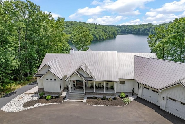 view of front facade featuring a water view, a porch, and a garage