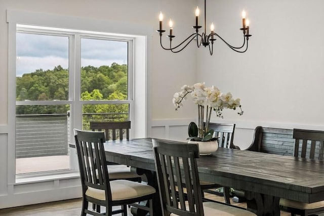 dining area with light hardwood / wood-style floors and an inviting chandelier