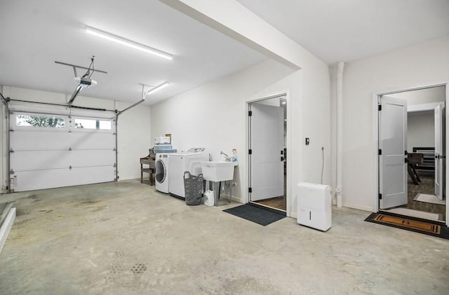 garage featuring sink, a garage door opener, and washing machine and clothes dryer