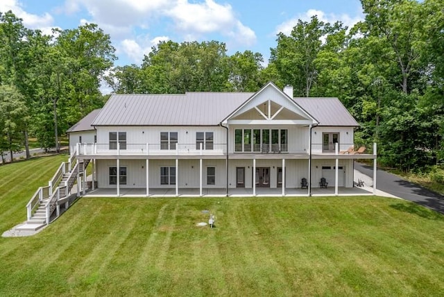 back of house with a patio and a lawn