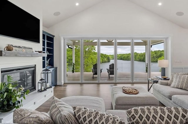 living room featuring a water view, dark wood-type flooring, and high vaulted ceiling