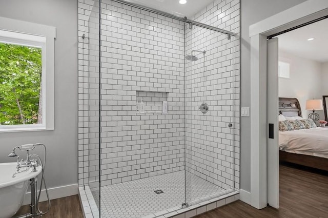 bathroom with plenty of natural light, wood-type flooring, and a shower with shower door