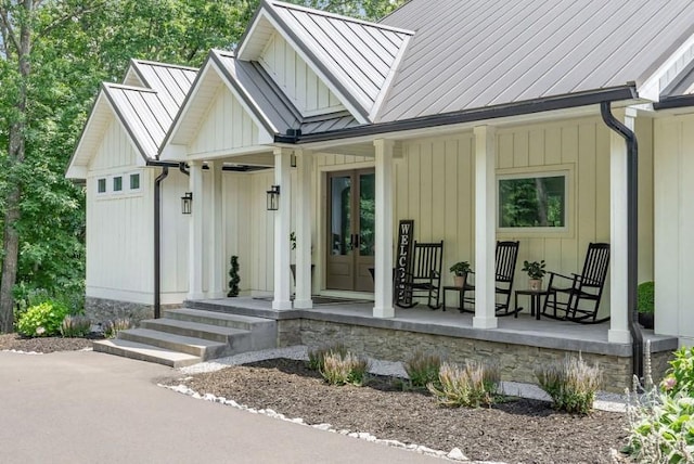 view of exterior entry with a porch and french doors