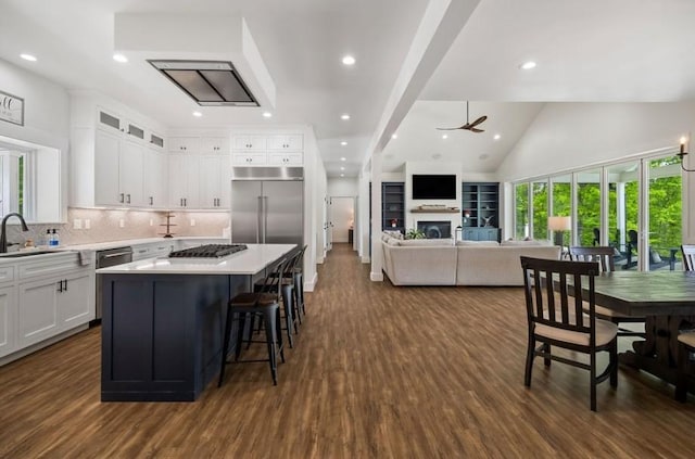 kitchen with white cabinets, ceiling fan, a center island, and dark hardwood / wood-style floors