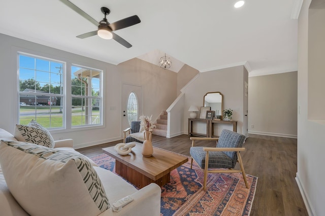 living room featuring crown molding, dark wood-type flooring, and ceiling fan with notable chandelier