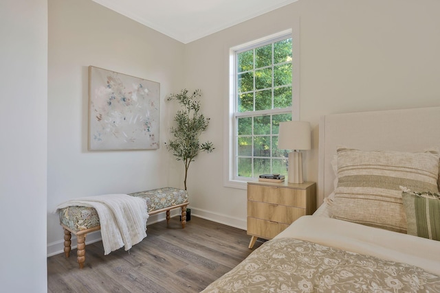 bedroom featuring wood-type flooring and ornamental molding