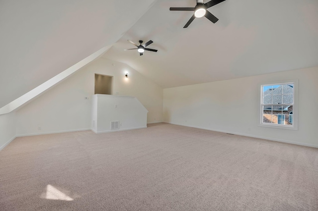 additional living space with light carpet, ceiling fan, and vaulted ceiling with skylight