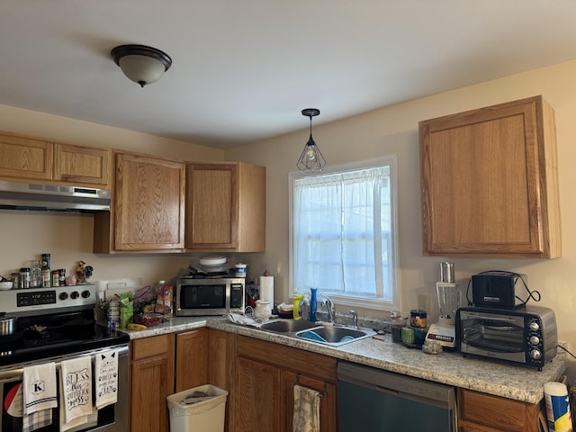 kitchen with sink, stainless steel appliances, and decorative light fixtures