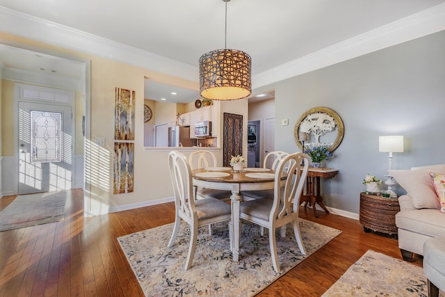 dining space featuring ornamental molding and dark wood-type flooring