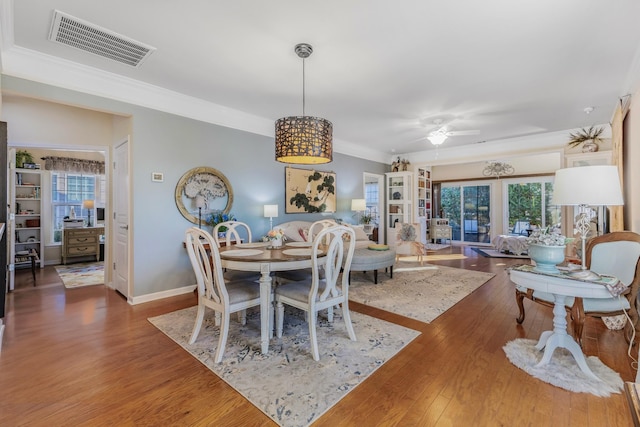 dining area with french doors, hardwood / wood-style flooring, ceiling fan, and crown molding