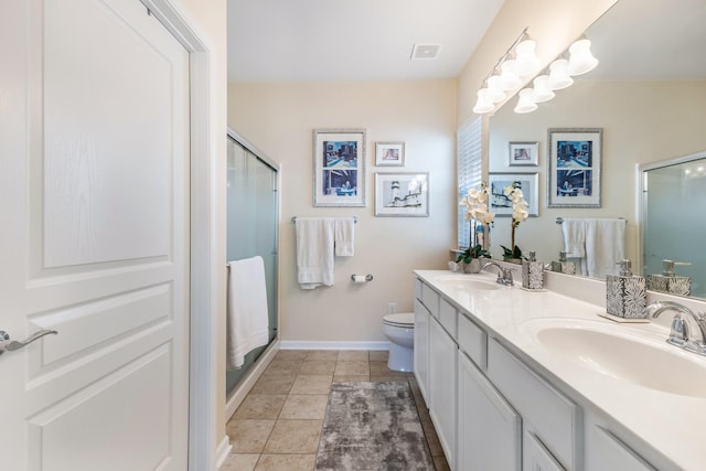 bathroom featuring tile patterned floors, vanity, toilet, and walk in shower