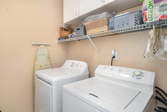 laundry area featuring washer and dryer and cabinets