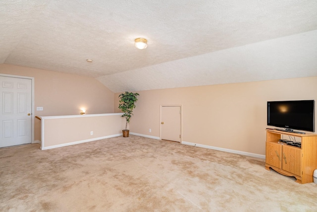 bonus room with a textured ceiling, lofted ceiling, and carpet floors