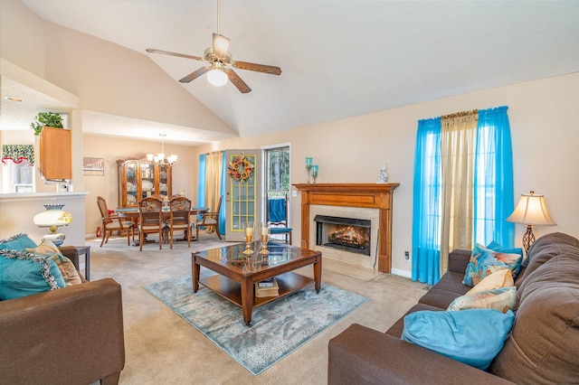 carpeted living room with ceiling fan with notable chandelier, high vaulted ceiling, and a wealth of natural light