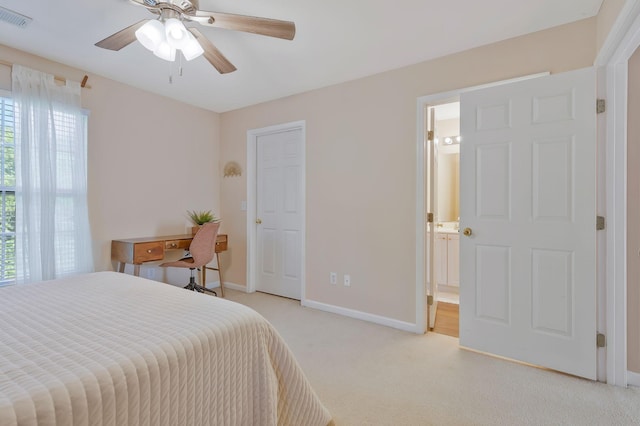 carpeted bedroom featuring ensuite bathroom and ceiling fan